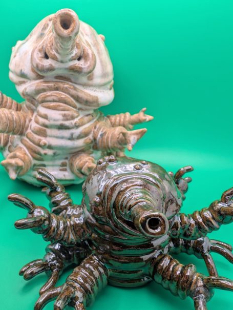 One large and one small standing tardigrade, their arms outstretched.  Bodies made of distorted coils 