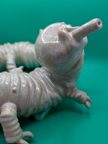 Ceramic sculpture - close up of face and front legs of pale centipede like creature with proboscis