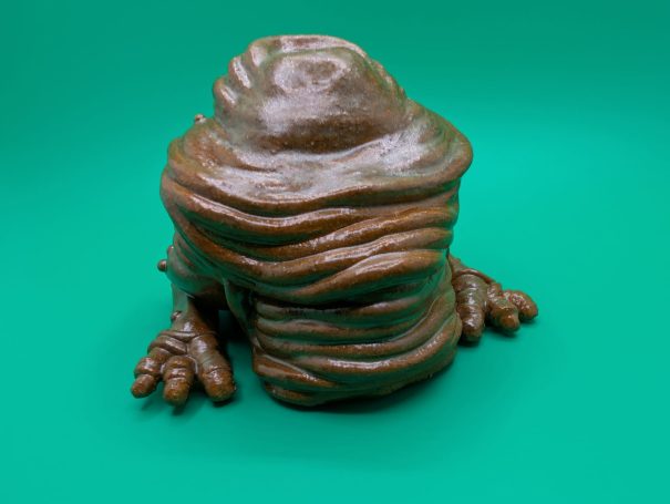 Ceramic sculpture - a squishy faceless frog-like creature with no face and a big butt