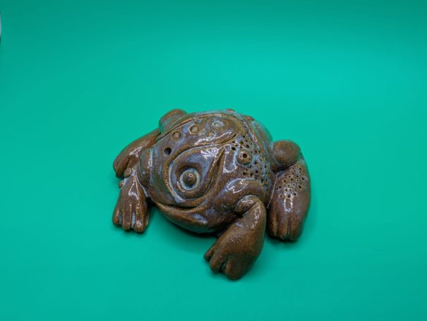 Ceramic sculpture - a compact frog-like creature carved with ritualistic symbols