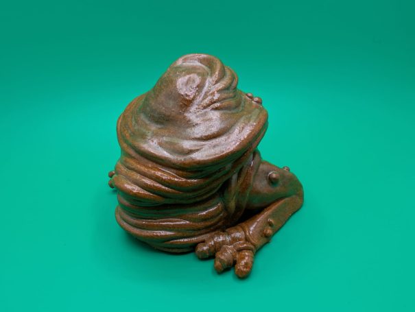 Ceramic sculpture - a squishy faceless frog-like creature with no face and a big butt