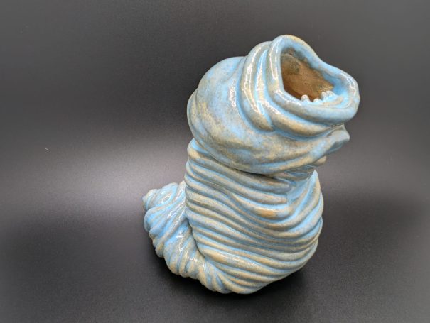 Ceramic sculpture - An eyeless thin coiled worm creature wailing with a large open toothy mouth